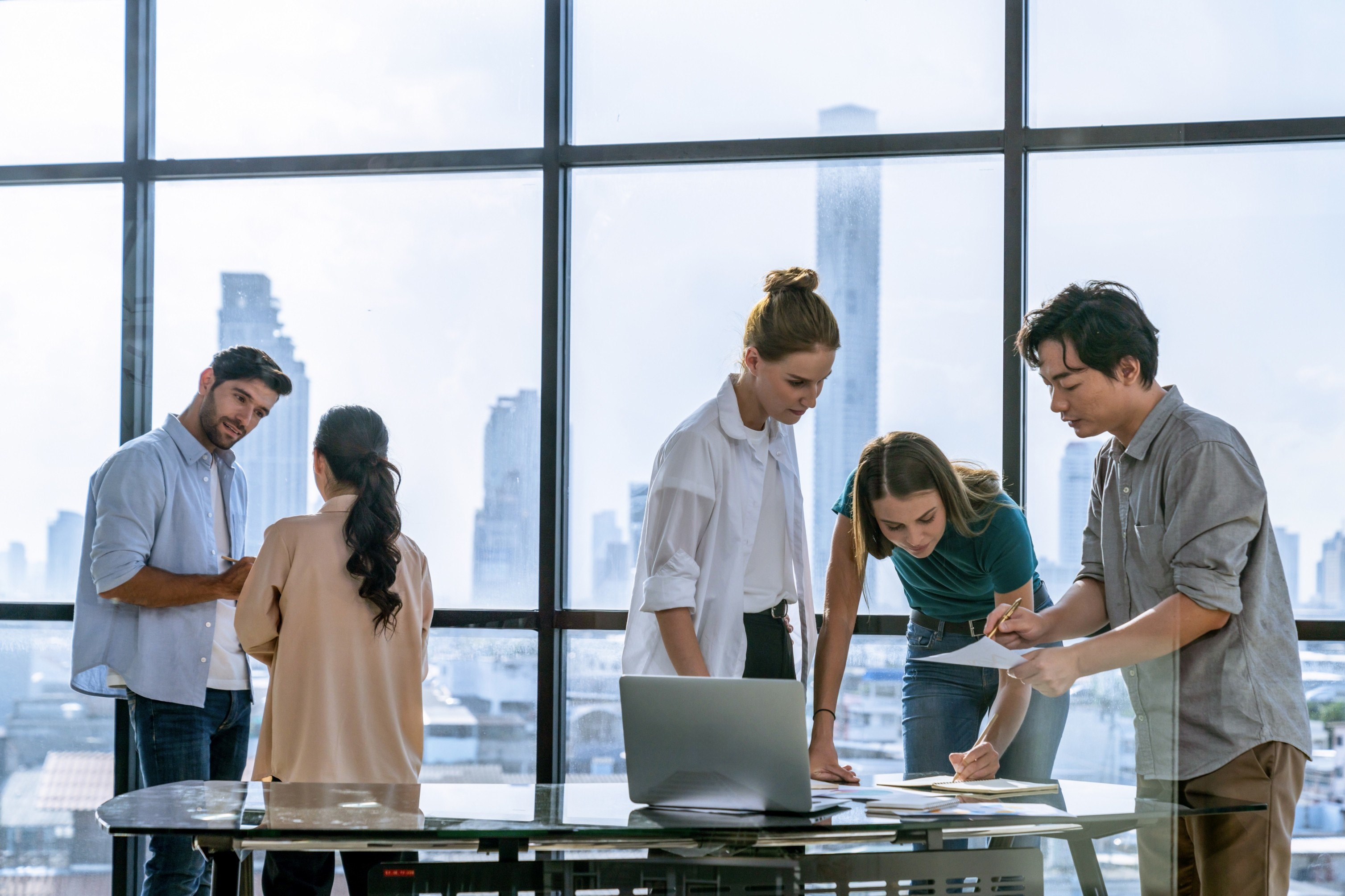 Photo of rows of books in a library with marble busts.
