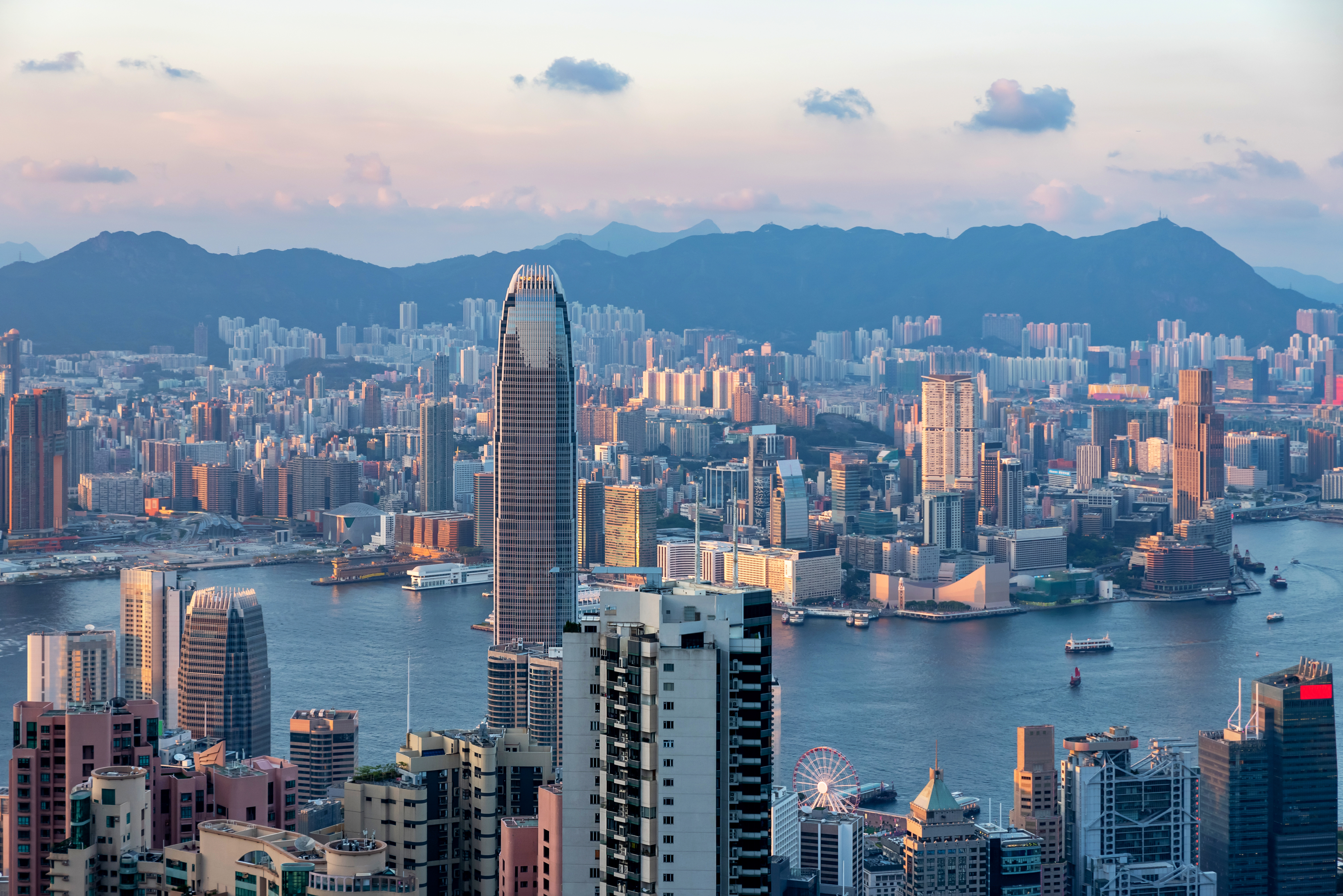 Two women sitting at a modern table talking with a city view behind them.